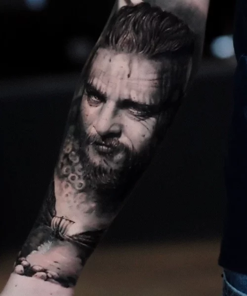 ragnar de la serie viking tatouage sur un avant bra realiste