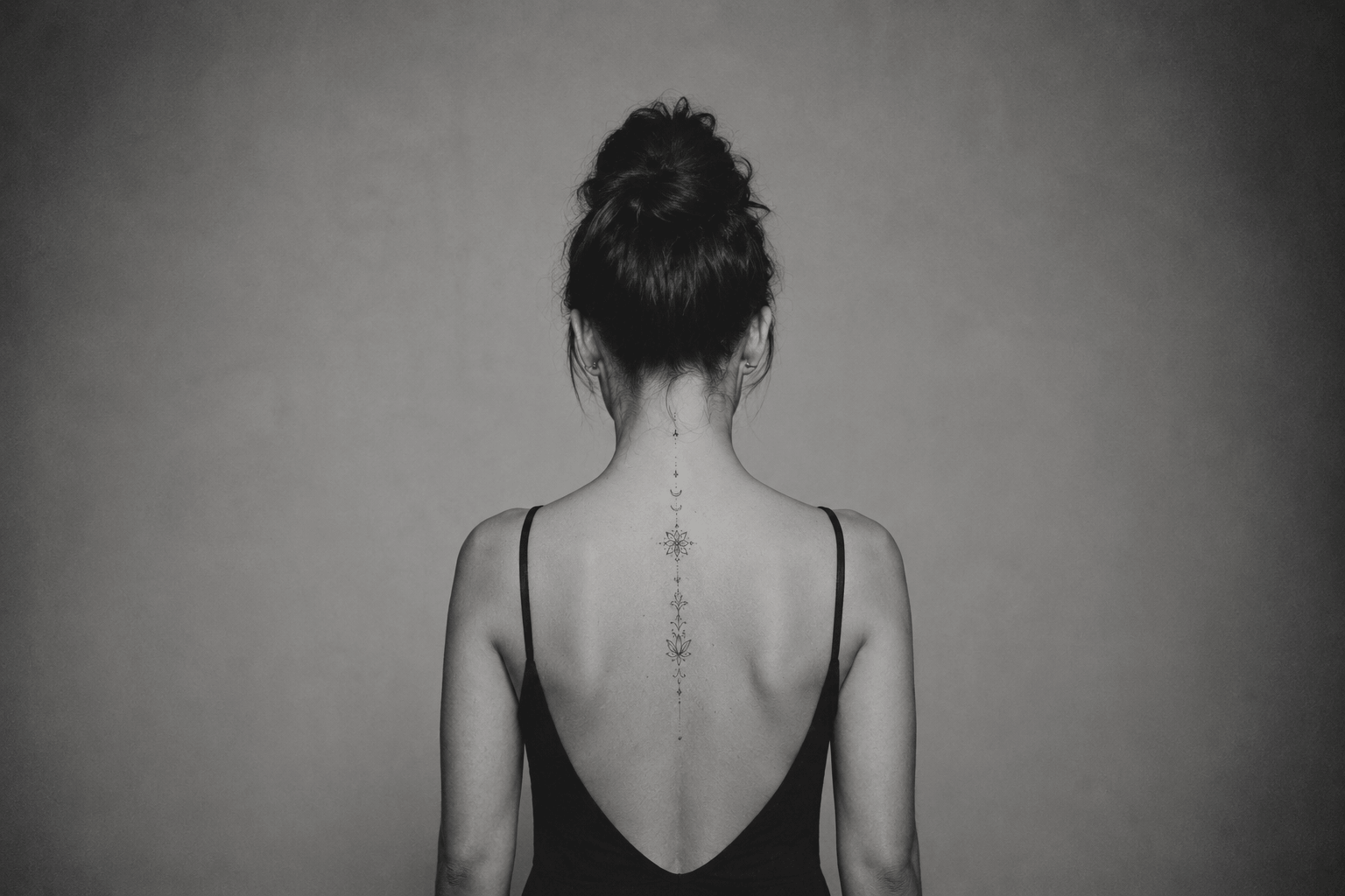 Tatouage ornemental fin descendant de la nuque au milieu du dos