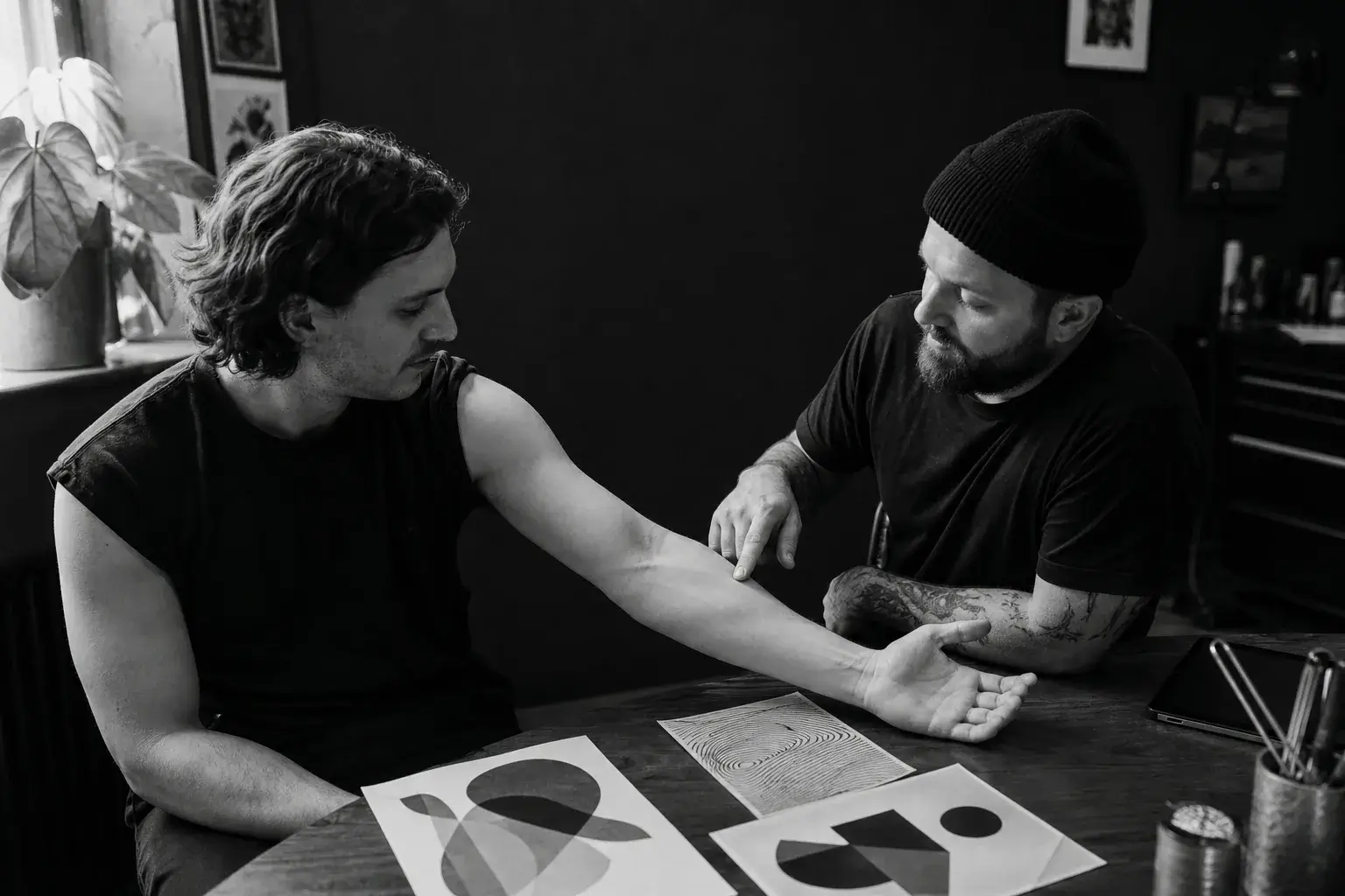 Tatoueur et client choisissant l’emplacement d’un tatouage sur le bras