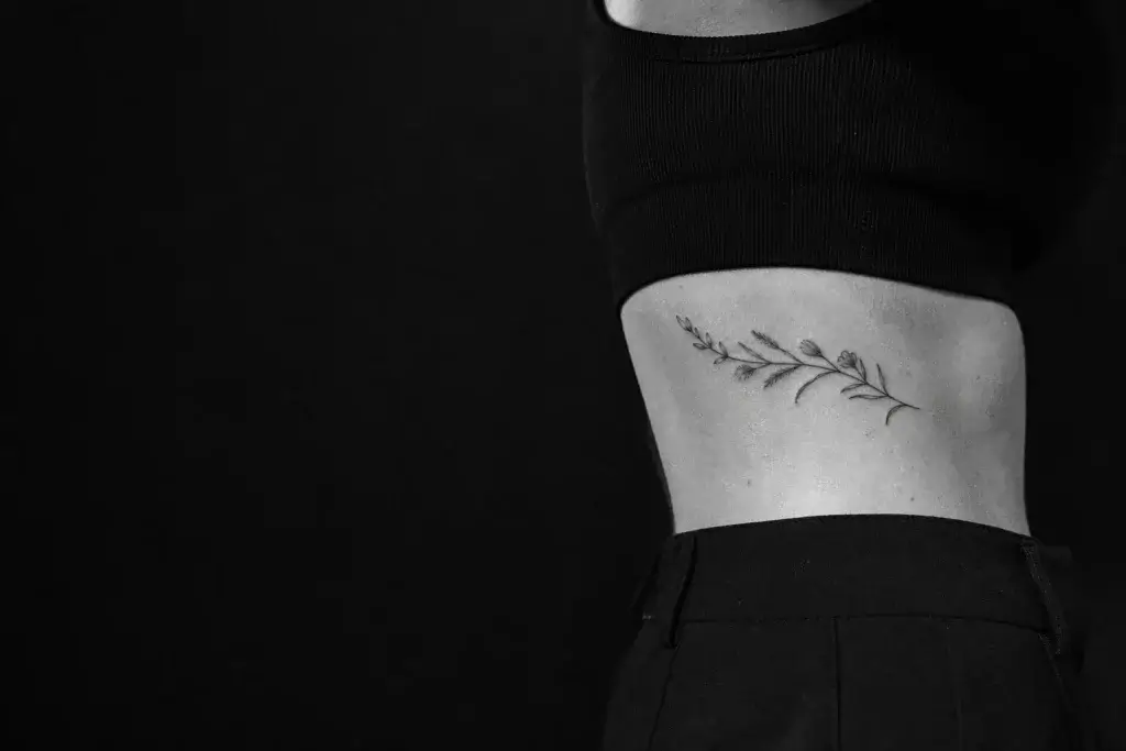Tatouage botanique fin cicatrisé sur le côté des côtes